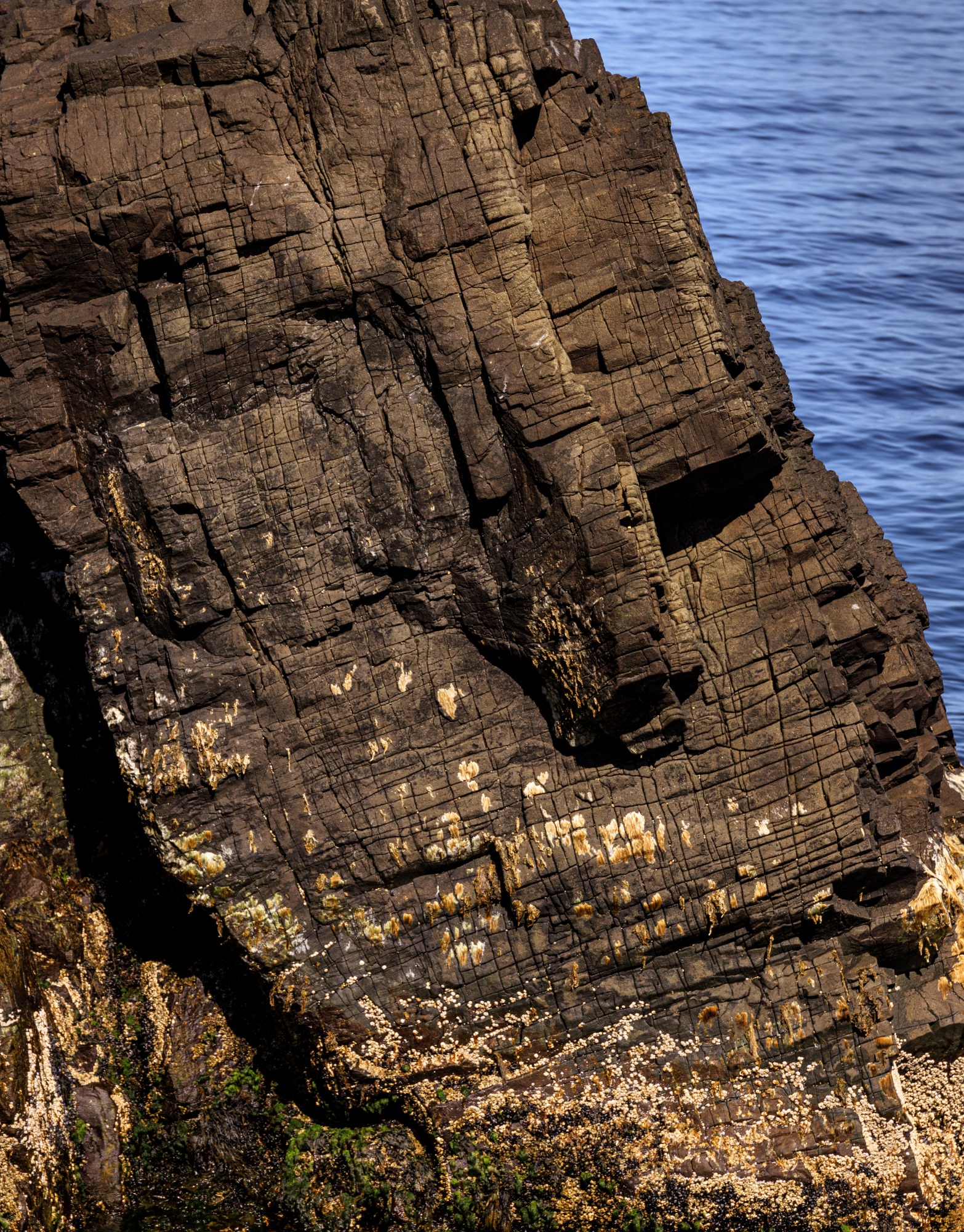 Ung stúlka horfir út á Atlantshaf við Páskahelli