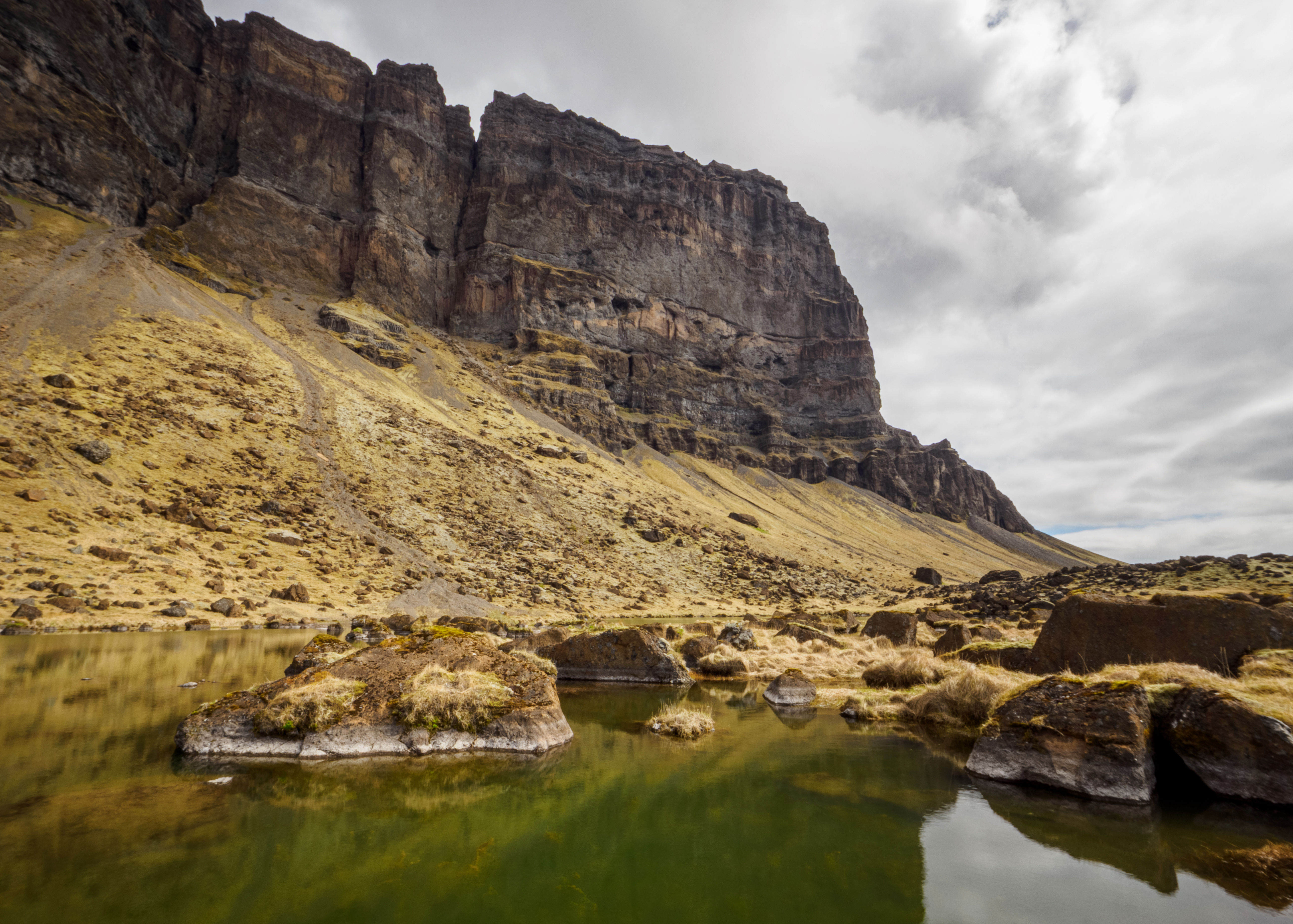Dramatískt fjallalandslag með skýjum yfir tindunum