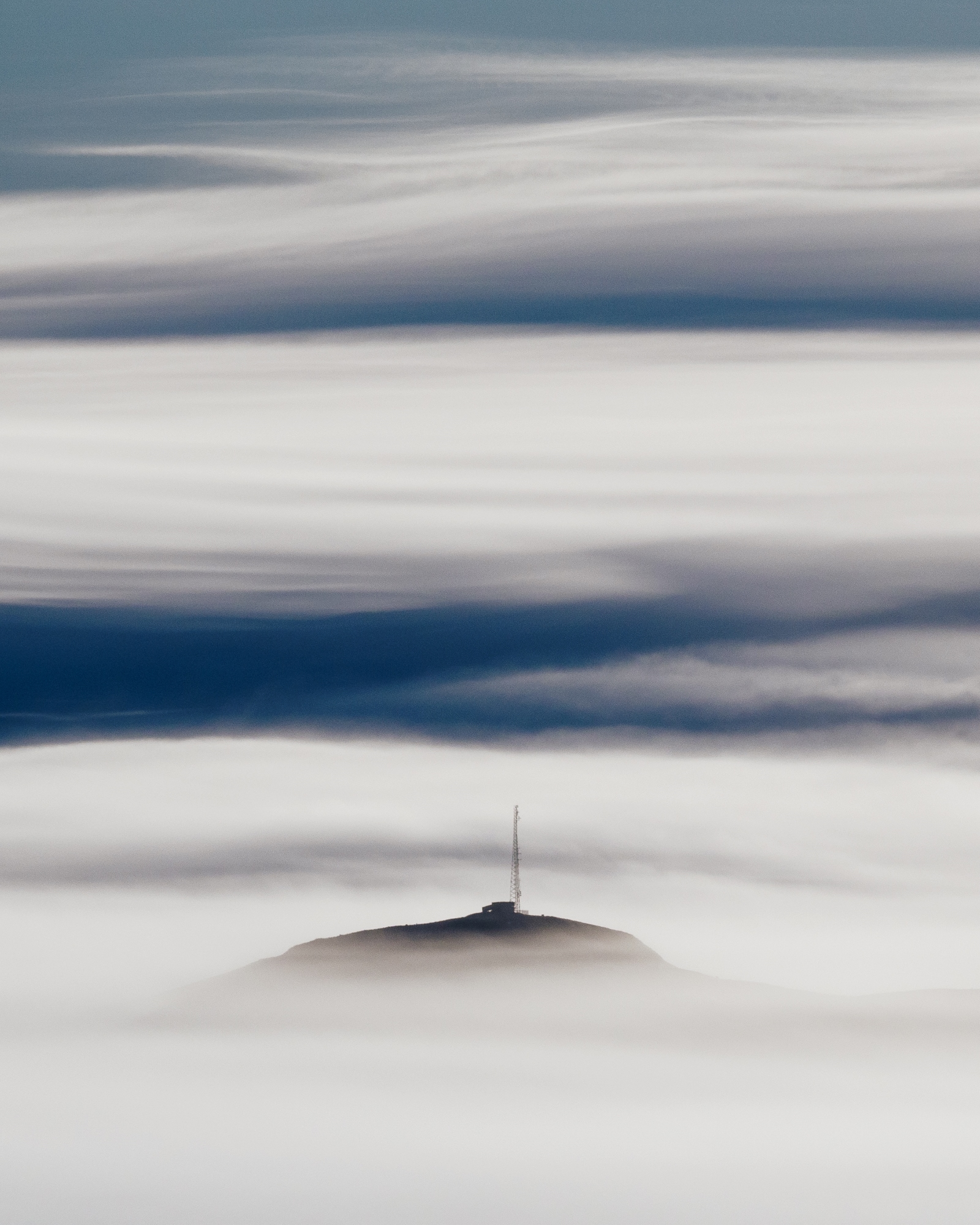 Áhrifamikil landslagsmynd af Esju að rísa upp úr skýjum